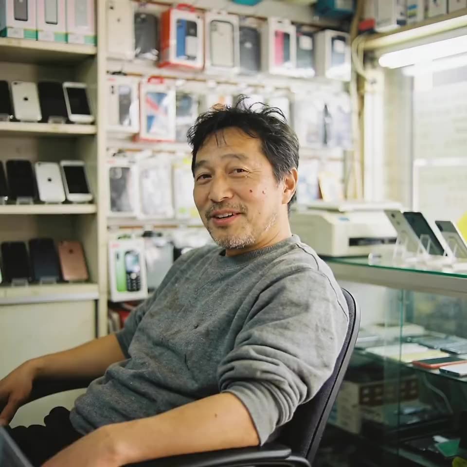 A phone store owner standing in his shop